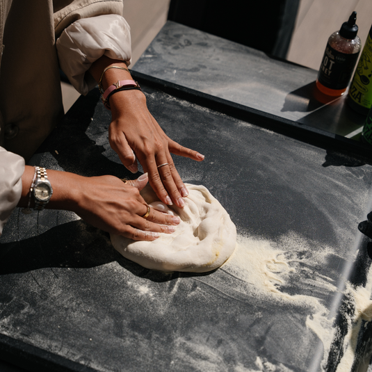 Stretching pizza dough on the Gozney Pizza Prep Board